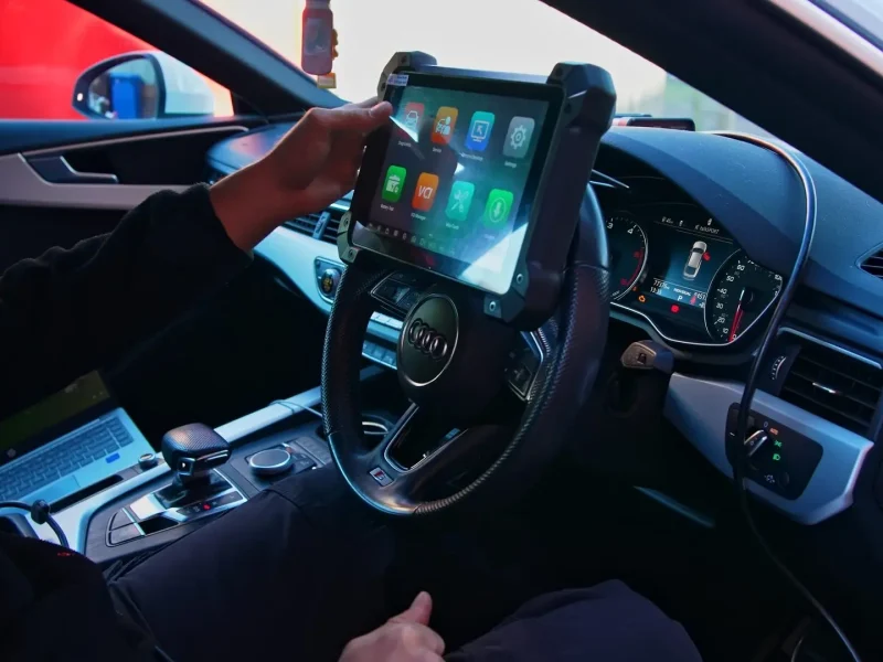 Diagnostic tablet connected to a car at the dashboard